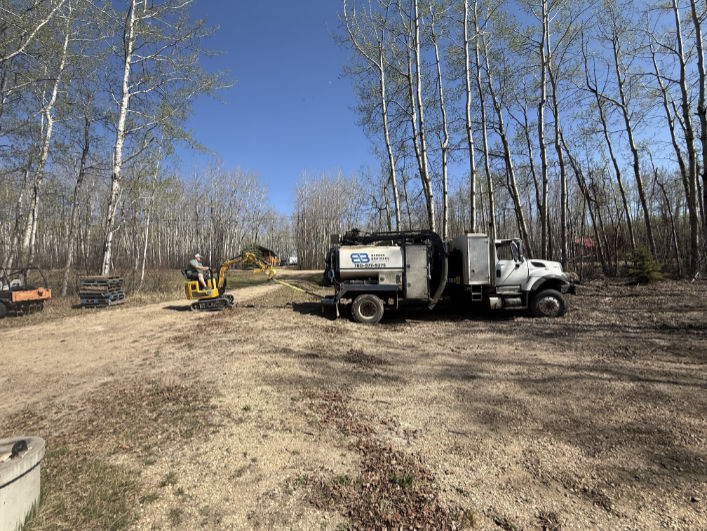Bergen Brothers Daylighting 4×4 hydrovac truck getting help after Alberta mud made a rural access road tougher than expected.