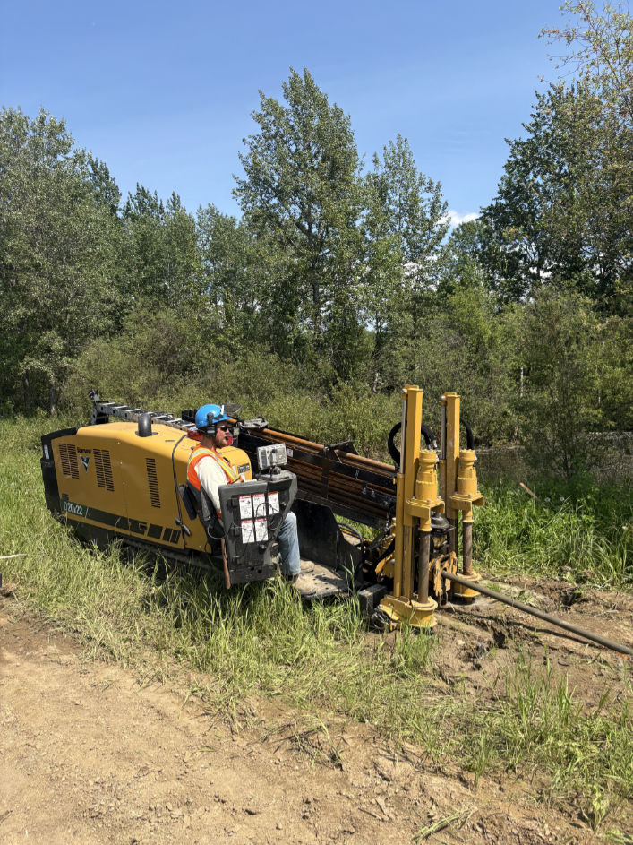 Bergen Brothers Daylighting directional drilling equipment completing an underground utility bore in a grassy work area.